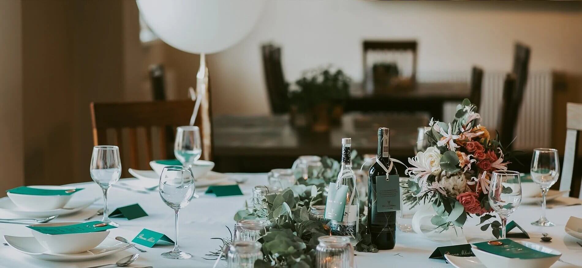 Butelka wina stojąca na stole podczas kolacji romantycznej dla gości restauracji z bukietem kwiatów i zstawą